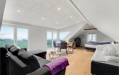 a living room with a couch and a bed and windows at Nice Home In Erslev With Wifi in Erslev
