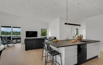 a kitchen and living room with a table and chairs at Nice Home In Spøttrup With Sauna in Spottrup