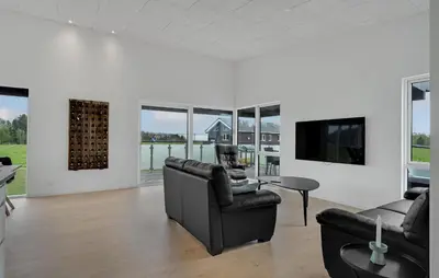 a living room with couches and a tv and windows at Nice Home In Spøttrup With Sauna in Spottrup