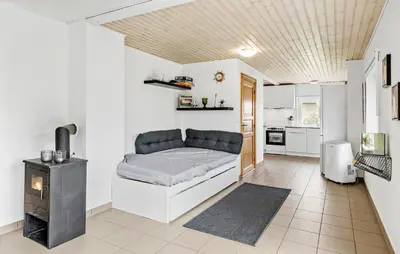 a living room with a couch and a kitchen at 3 Bedroom Amazing Home In Vesløs in Øsløs