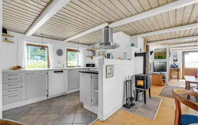 a kitchen with white cabinets and a wooden ceiling at Gorgeous Home In Thyholm With Kitchen in Thyholm