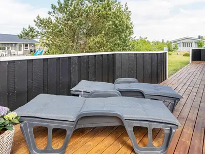 four tables and chairs on a deck with a fence at 7 person holiday home in Løgstør-By Traum in Løgsted