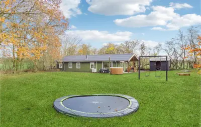 a yard with a trampoline in front of a house at Stunning Home In Nibe With Kitchen in Store Ajstrup
