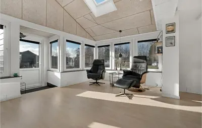 a room with two chairs and a table and windows at Lovely Home In Hurup Thy With Sauna in Sønder Ydby