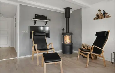 a living room with two chairs and a fireplace at Lovely Home In Hurup Thy With Sauna in Sønder Ydby