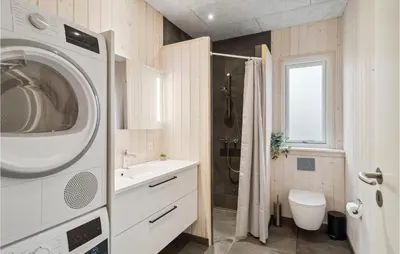 a bathroom with a washing machine and a sink at 5 Bedroom Lovely Home In Højslev in Højslev
