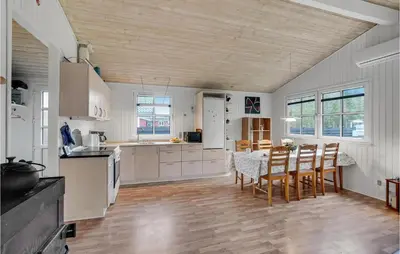 a kitchen with white cabinets and a table and chairs at 3 Bedroom Beautiful Home In Højslev in Højslev
