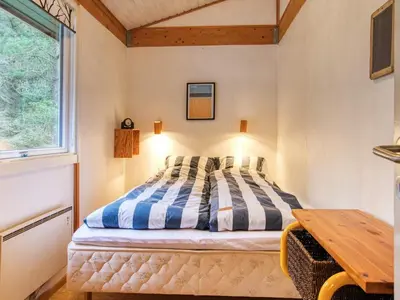 a bedroom with a bed and a wooden table at 6 person holiday home in Blokhus-By Traum in Blokhus