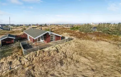 a small red house on top of a hill at 3 Bedroom Lovely Home In Frøstrup in Frøstrup