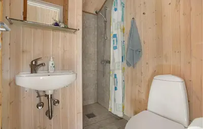 a bathroom with a toilet and a sink and a shower at 3 Bedroom Lovely Home In Frøstrup in Frøstrup