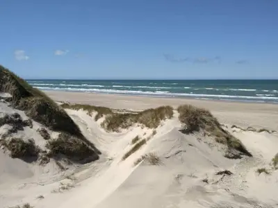 a sand dune on a beach with the ocean at 6 person holiday home in Saltum-By Traum in Saltum
