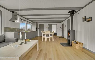 a living room with a table and a kitchen with a fireplace at Lovely Home In Hurup Thy With Wifi in Sønder Ydby