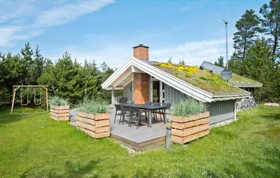a small house with a table on a deck at Gorgeous Home In Blokhus With Wifi in Blokhus
