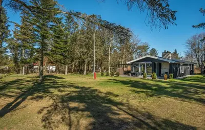 a house with a tree in front of a yard at 3 Bedroom Cozy Home In Thyholm in Thyholm