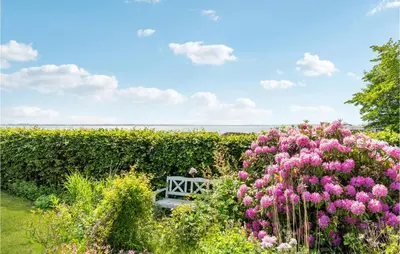 a bench in the middle of a garden with flowers at Gorgeous Home In Øster Assels in Øster Assels