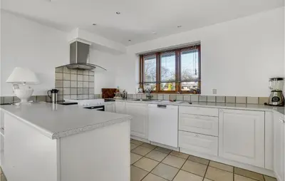 a white kitchen with white cabinets and a window at Gorgeous Home In Øster Assels in Øster Assels