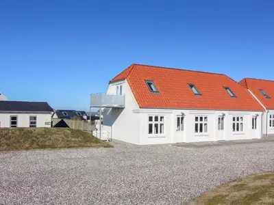 a white house with an orange roof at Holiday Home Ena - 75m from the sea by Interhome in Lemvig