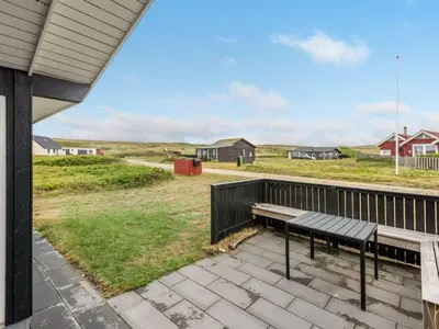 a bench on the deck of a house at Holiday Home Arni - 150m from the sea by Interhome in Lemvig