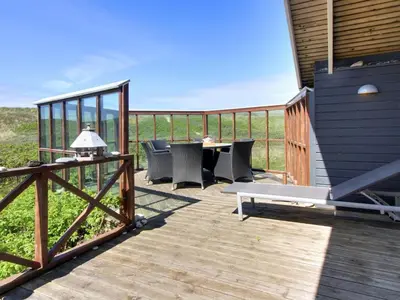 a patio with a table and chairs on a deck at Holiday Home Egidia - 50m from the sea by Interhome in Lemvig