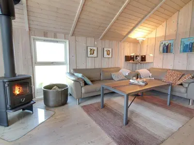 a living room with a couch and a wood stove at Holiday Home Egidia - 50m from the sea by Interhome in Lemvig