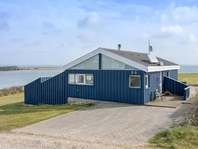 a blue house sitting on top of a beach at Holiday Home Rajna - 95m to the fjord by Interhome in Lemvig