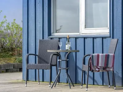 two chairs and a table on a porch at Holiday Home Rajna - 95m to the fjord by Interhome in Lemvig