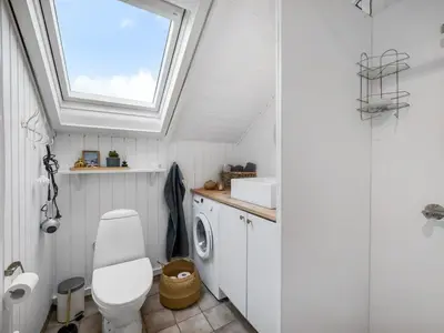 a bathroom with a toilet and a sink and a window at Holiday Home Kamile - 400m from the sea by Interhome in Harboør