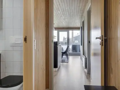 a hallway with a room with a table and a chair at Holiday Home Hebba - 300m from the sea by Interhome in Harboør