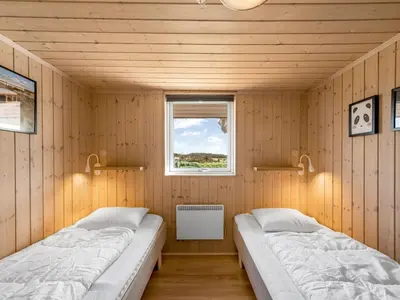 two beds in a room with a window at Holiday Home Floriana - 650m from the sea by Interhome in Harboør