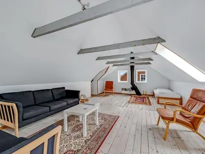 a living room with a black couch and chairs at Holiday Home Orvo - 150m from the sea by Interhome in Harboør
