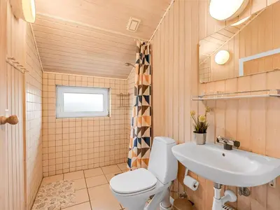 a bathroom with a toilet and a sink at Holiday Home Elnur - 100m from the sea by Interhome in Harboør