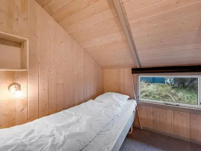 a small room with a bed and a window at Holiday Home Mimo - 150m from the sea by Interhome in Harboør