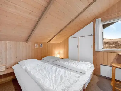 a large bed in a room with a window at Holiday Home Mimo - 150m from the sea by Interhome in Harboør