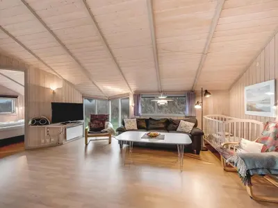 a living room with a couch and a table at Holiday Home Mimo - 150m from the sea by Interhome in Harboør