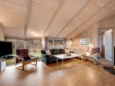 a living room with a couch and a table at Holiday Home Mimo - 150m from the sea by Interhome in Harboør