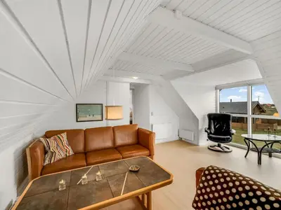 a living room with a couch and a table at Holiday Home Eringisl - 50m from the sea by Interhome in Harboør
