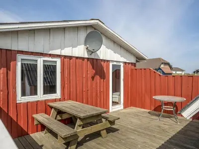 a wooden deck with a picnic table and a fence at Holiday Home Hansen - 75m from the sea by Interhome in Harboør