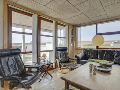 a living room with leather chairs and a table at Holiday Home Hansen - 75m from the sea by Interhome in Harboør