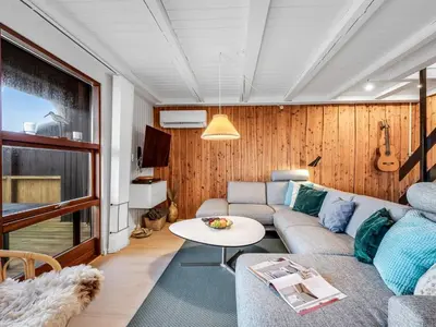 a living room with a couch and a table at Holiday Home Kristanna - 150m from the sea by Interhome in Harboør