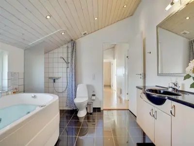 a bathroom with a tub and a toilet and a sink at Holiday Home Hildegunda - 950m from the sea by Interhome in Harboør
