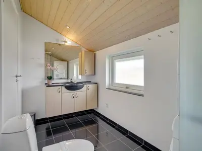 a bathroom with a toilet and a sink at Holiday Home Hildegunda - 950m from the sea by Interhome in Harboør