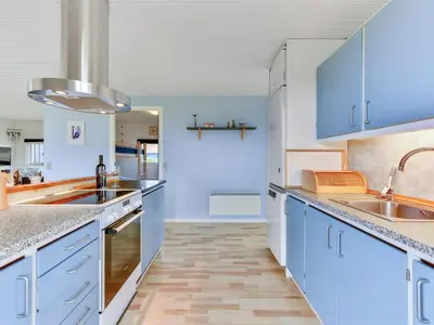 a kitchen with blue cabinets and marble counter tops at Holiday Home Thamara - 350m from the sea by Interhome in Harboør