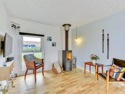 a living room with a wood stove in a room at Holiday Home Thamara - 350m from the sea by Interhome in Harboør