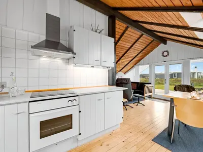 a kitchen with white cabinets and a stove top oven at Holiday Home Olesia - 250m from the sea by Interhome in Harboør