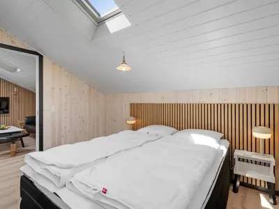 a bedroom with a large white bed in a room at Holiday Home Arla - 200m from the sea by Interhome in Harboør