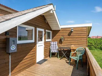 a patio with a table and chairs on a house at Holiday Home Arla - 200m from the sea by Interhome in Harboør