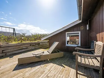 a patio with two chairs on a wooden deck at Holiday Home Brigit - 200m from the sea by Interhome in Harboør