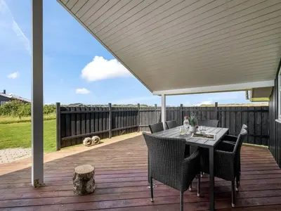 a patio with a table and chairs on a deck at Holiday Home Eemil - 700m from the sea by Interhome in Harboør