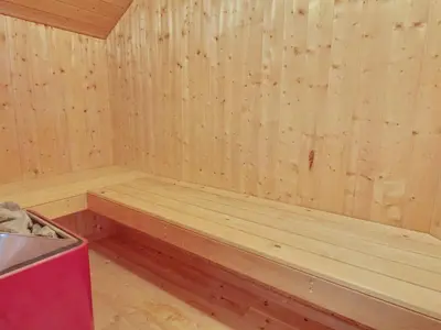 a sauna with a wooden bench in a room at Holiday Home Filip - 100m from the sea by Interhome in Harboør