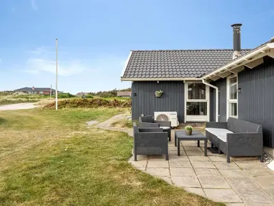 a house with two couches and a patio at Holiday Home Filip - 100m from the sea by Interhome in Harboør